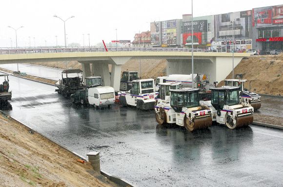 Foto: Sebastian Wołosz, Drogowcy z wylewaniem kolejnej warstwy asfaltu czekają aż przestanie padać deszcz.